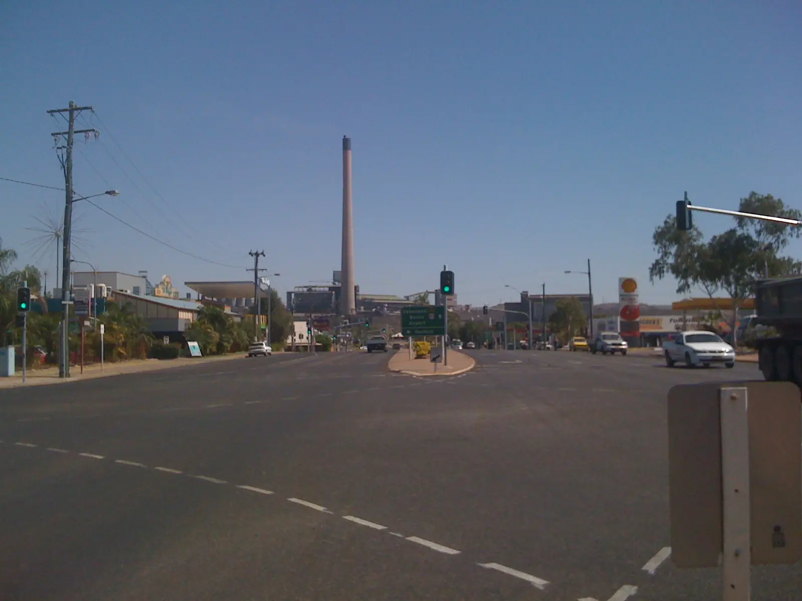 A main road in Mount Isa with the mine's tall smelter stack rising behind the town