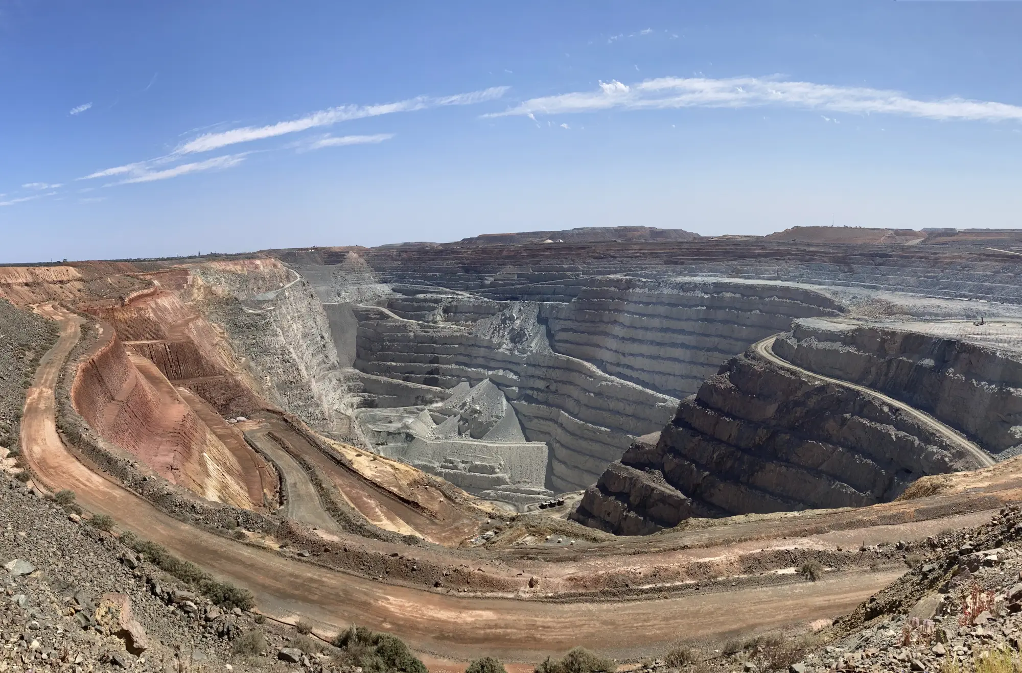 The Super Pit open-cut gold mine at Kalgoorlie, with benches stepping down into the pit under a blue sky
